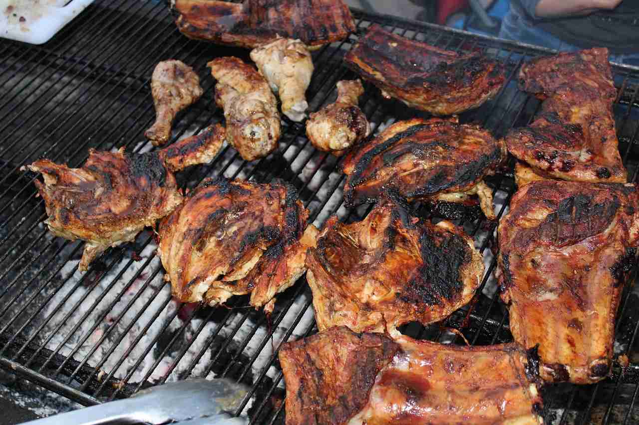 Grilled meats cooking over a commercial barbecue pit at a busy restaurant, showcasing the type of operation that may require Restaurant opening costs financing, food service equipment financing, commercial kitchen buildout financing, and restaurant operational financing to support startup, expansion, and daily business needs.