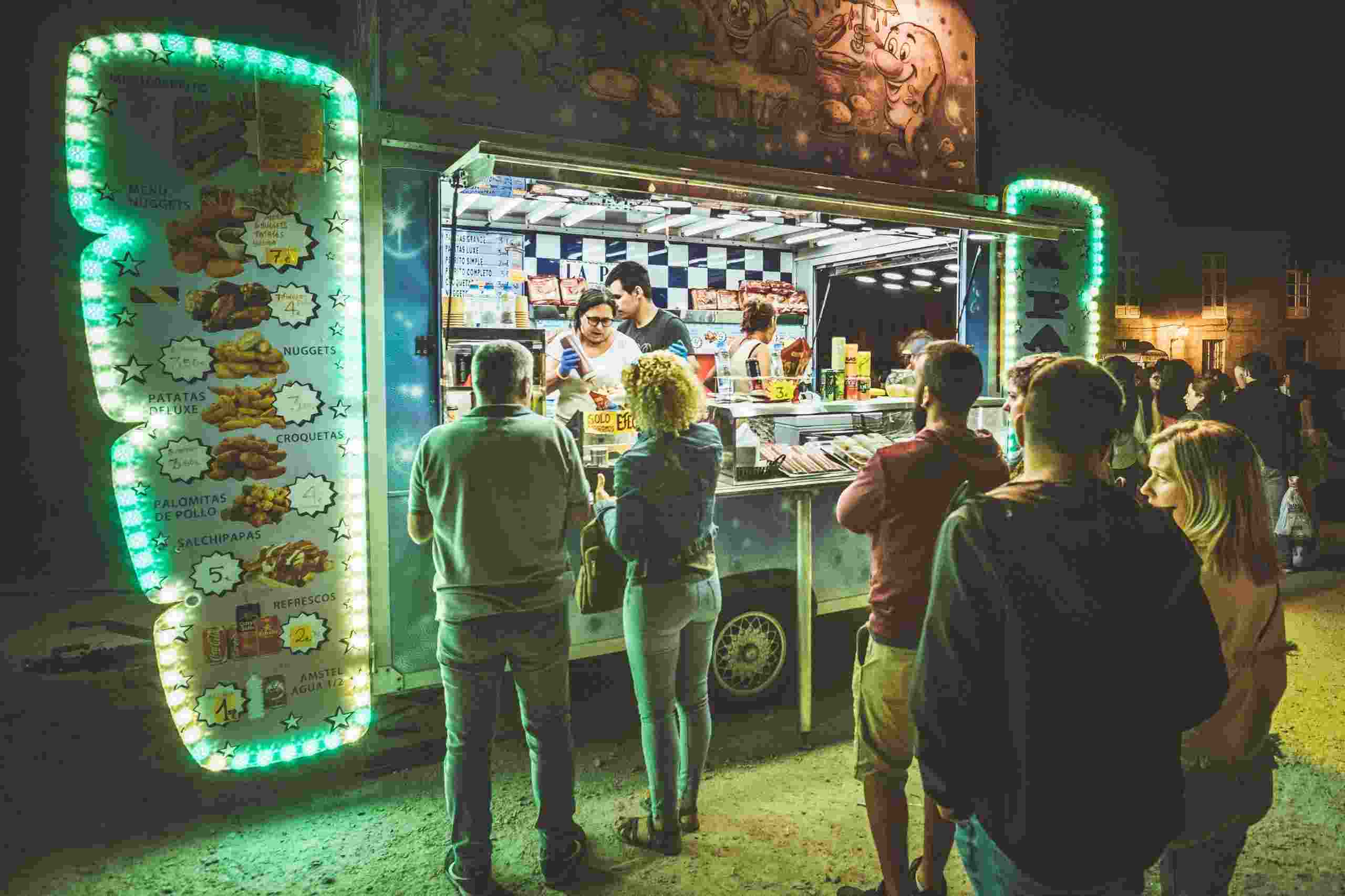 Busy food truck serving customers at a nighttime event, illustrating Food Truck Financing, Restaurant Purchasing Capital, Restaurant Working Capital Loans, Financing a Restaurant Acquisition, and Hospitality Working Capital used by food service businesses to fund equipment, inventory, acquisitions, daily operations, and business growth.
