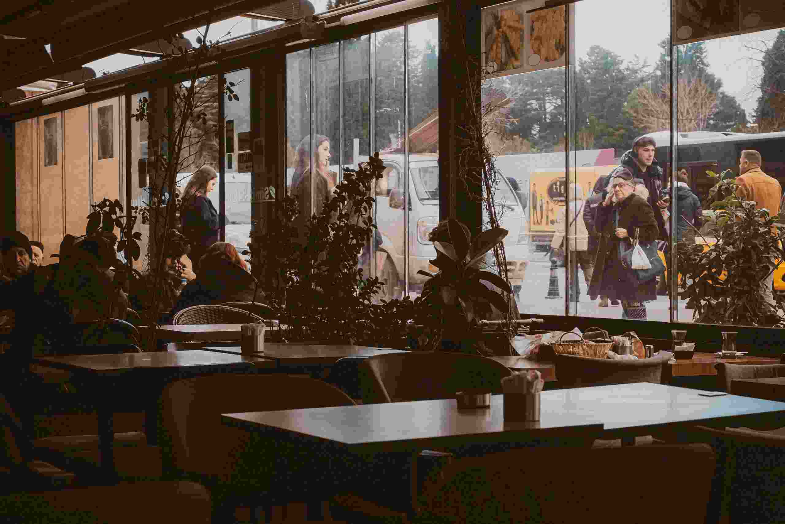 Busy restaurant dining room with guests, large windows, and community gathering atmosphere, representing Franchise Acquisition Financing, Restaurant Land Financing, Restaurant Expansion Loans, Restaurant Franchise Funding, and Restaurant Software Financing for restaurant owners seeking capital to acquire franchises, purchase property, expand locations, and upgrade business technology systems.