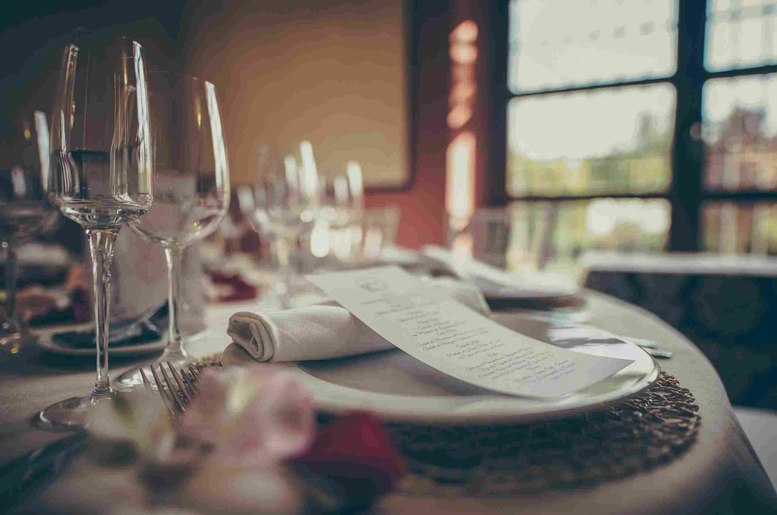 Elegant fine dining restaurant table setting with wine glasses, menu, and upscale décor, representing Apply for Restaurant Loan, Banquet Facility Financing, Restaurant Training Financing, How to Finance a New Restaurant, and Restaurant Finance Specialists helping hospitality businesses launch, train staff, expand event facilities, and secure restaurant funding.