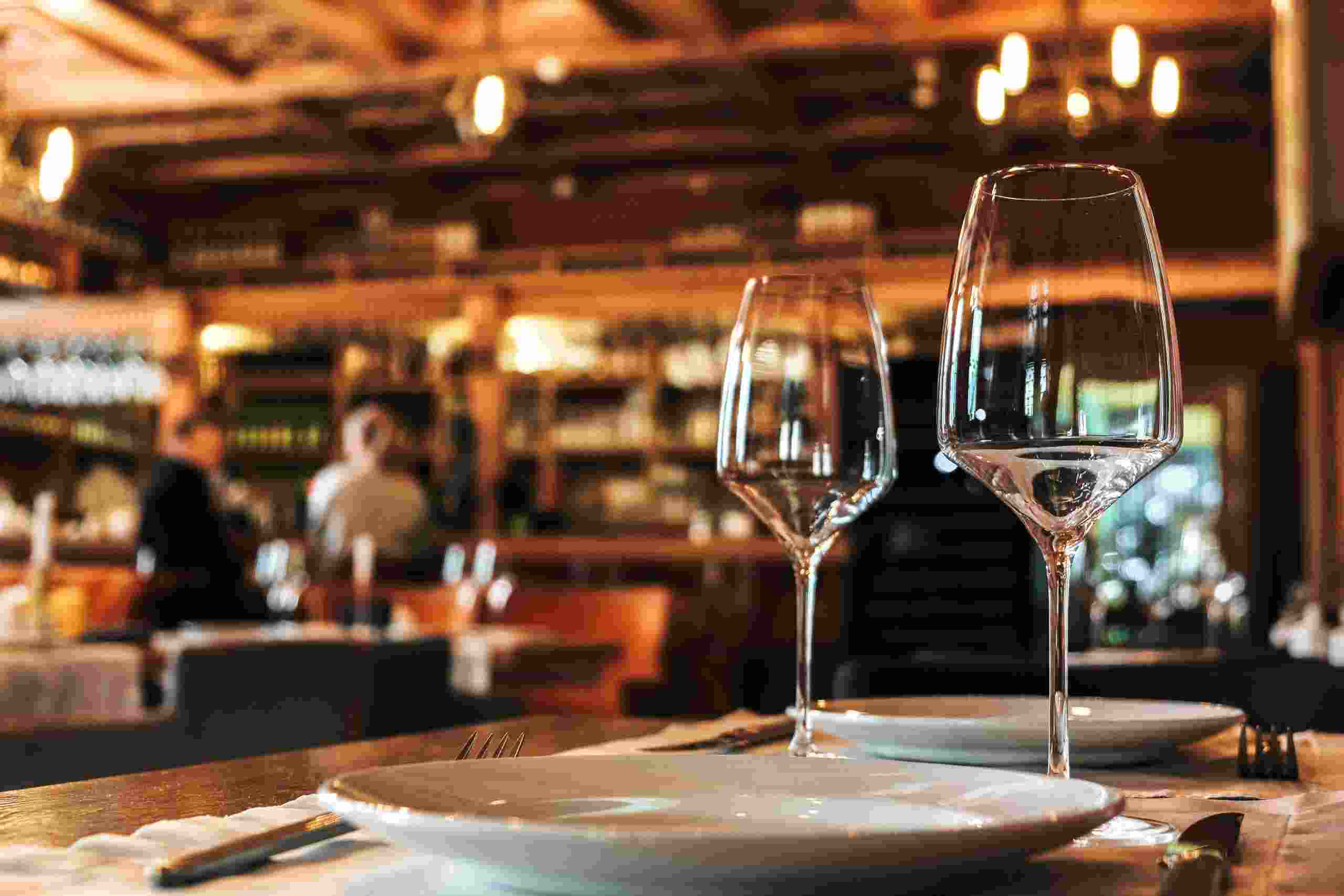 Elegant Italian restaurant dining area with wine glasses, table settings, and warm ambient lighting, representing Restaurant Business Funding, Franchise Location Financing, Restaurant Buyout Loans, Restaurant Remodeling Loans, and Hospitality Acquisition Financing for restaurant owners expanding, acquiring, renovating, and growing hospitality businesses.