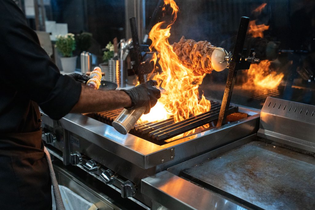 Chef cooking over an open-flame commercial restaurant grill, representing Funding to open a restaurant, a restaurant financing blog, restaurant funding, restaurant line of credit, and restaurant line of credit lenders for equipment, startup, and working-capital needs.